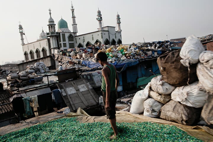Radheshyam Nehrua, from Uttar Pradesh, dries plastic chips on the roof of a recycling shed in Dharavi. Nehrua came to Mumbai for work and earns three thousand rupees a month, most of which he sends home to his family in northern India.
