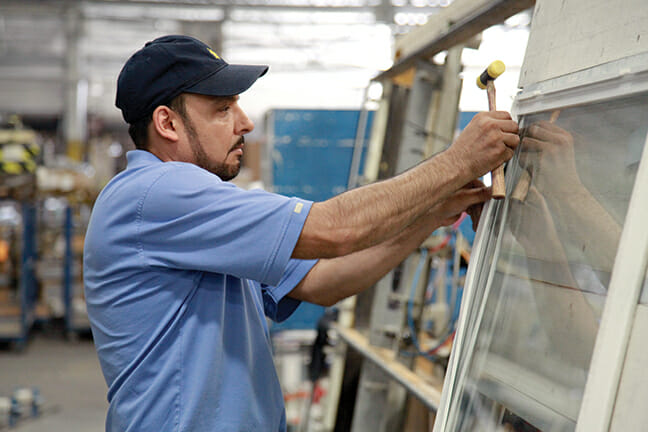 Gilberto Reyes prepares a window sash for installation.